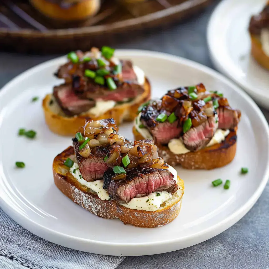 A plate of toasted bread topped with sliced steak, creamy spread, caramelized onions, and chopped green onions.