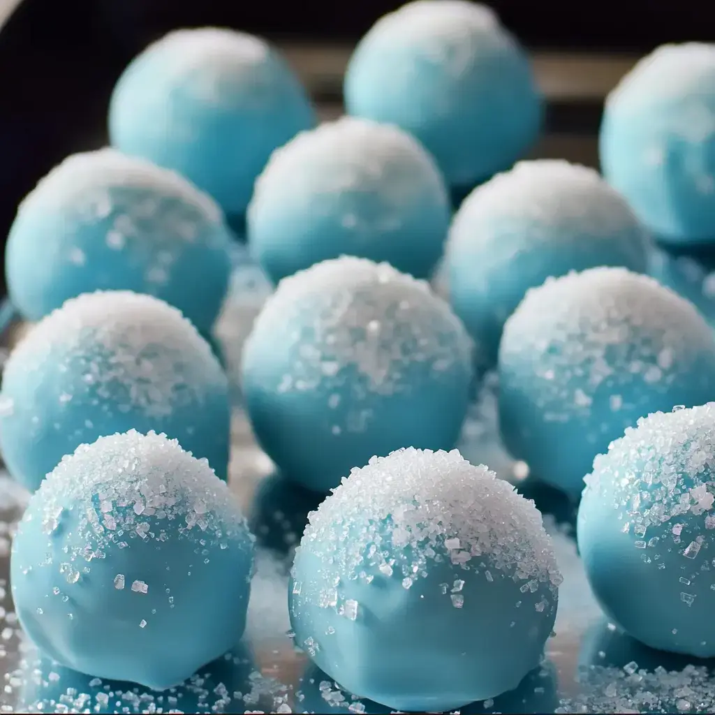 A tray of bright blue dessert balls coated in sugar granules.