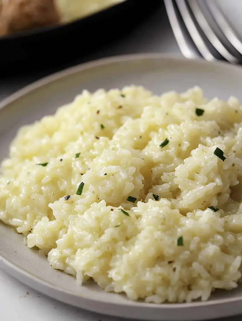 A serving of creamy, herb-infused risotto on a light-colored plate.