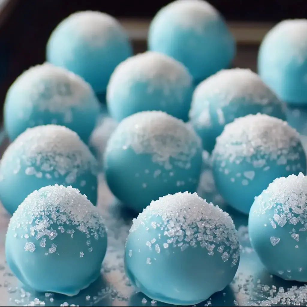 A tray of blue chocolate balls topped with white sugar crystals.