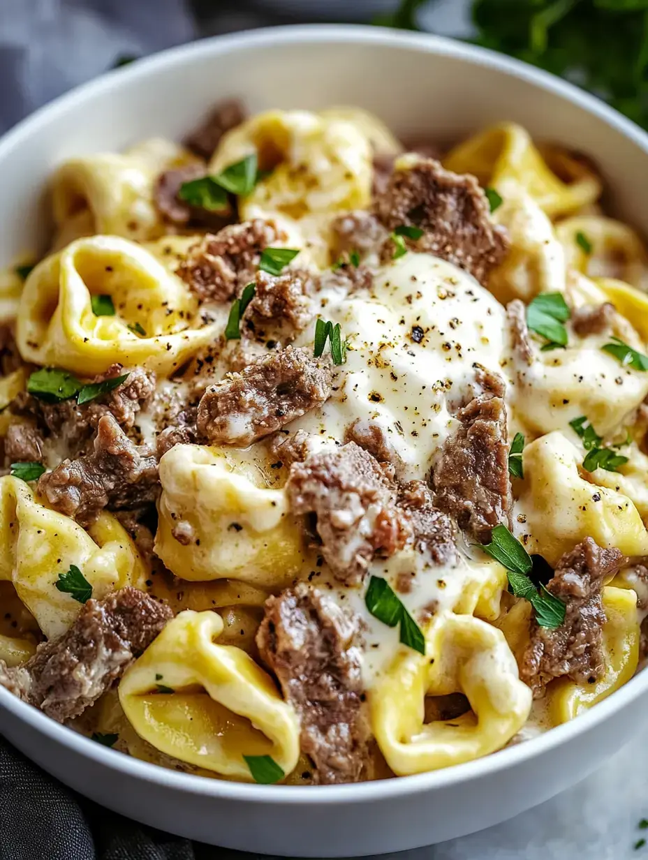 A bowl of creamy pasta topped with pieces of beef and garnished with parsley.