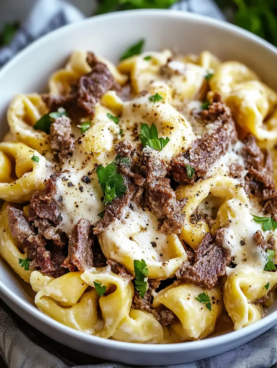 A bowl of pasta topped with pieces of beef, melted cheese, and garnished with parsley.