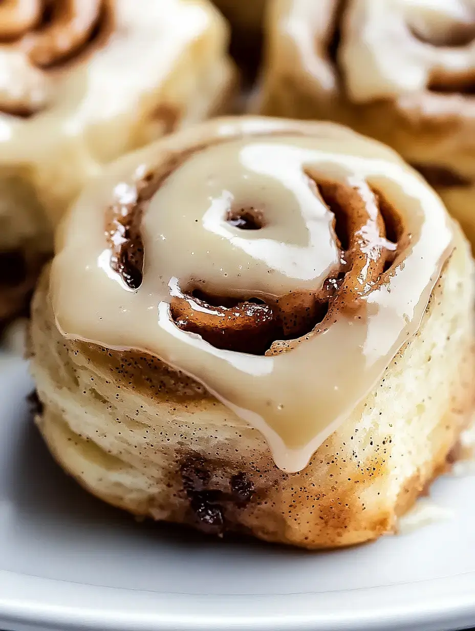 A close-up of a freshly baked cinnamon roll topped with creamy frosting.