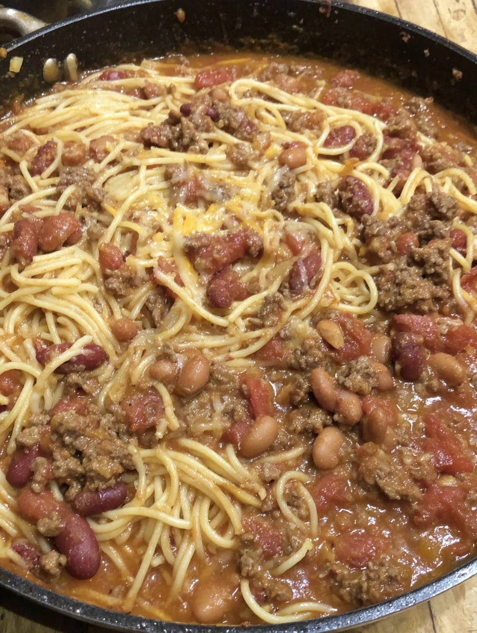Cowboy spaghetti with ground beef, chili beans, smoky tomato sauce, cheddar, and crisp bacon
